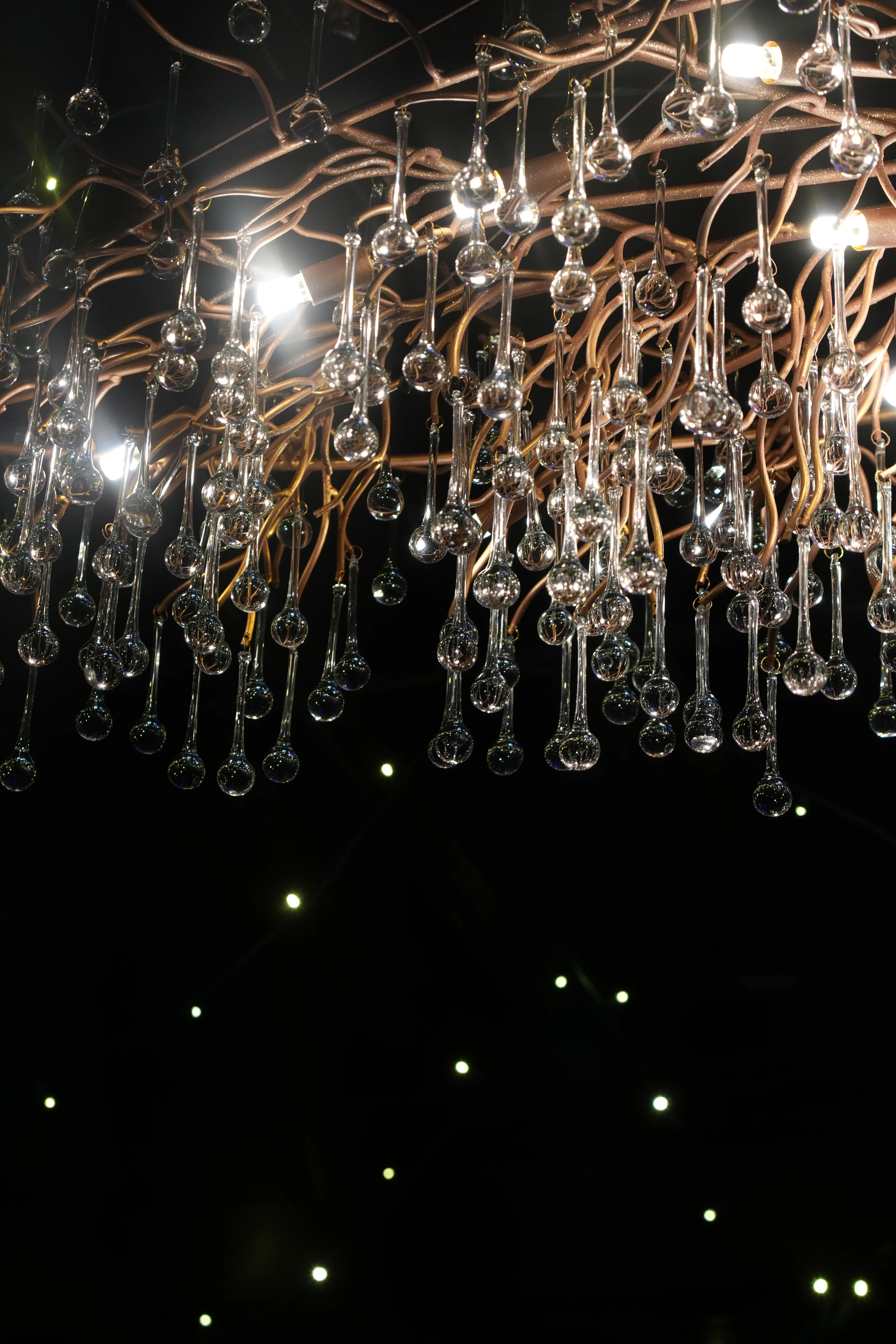 Cluster chandelier of suspended glass droplets and Edison bulbs above the bar at Brooklyn's.